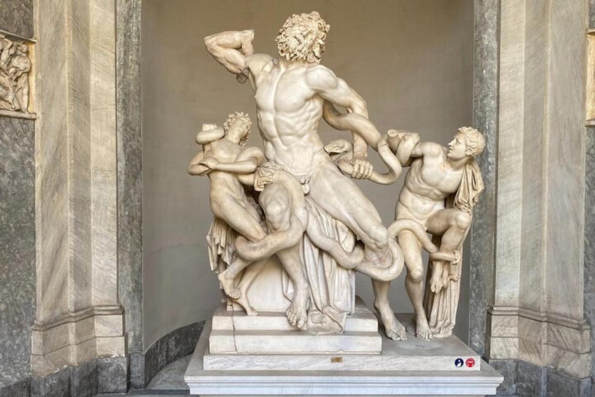a statue in a building with people around him