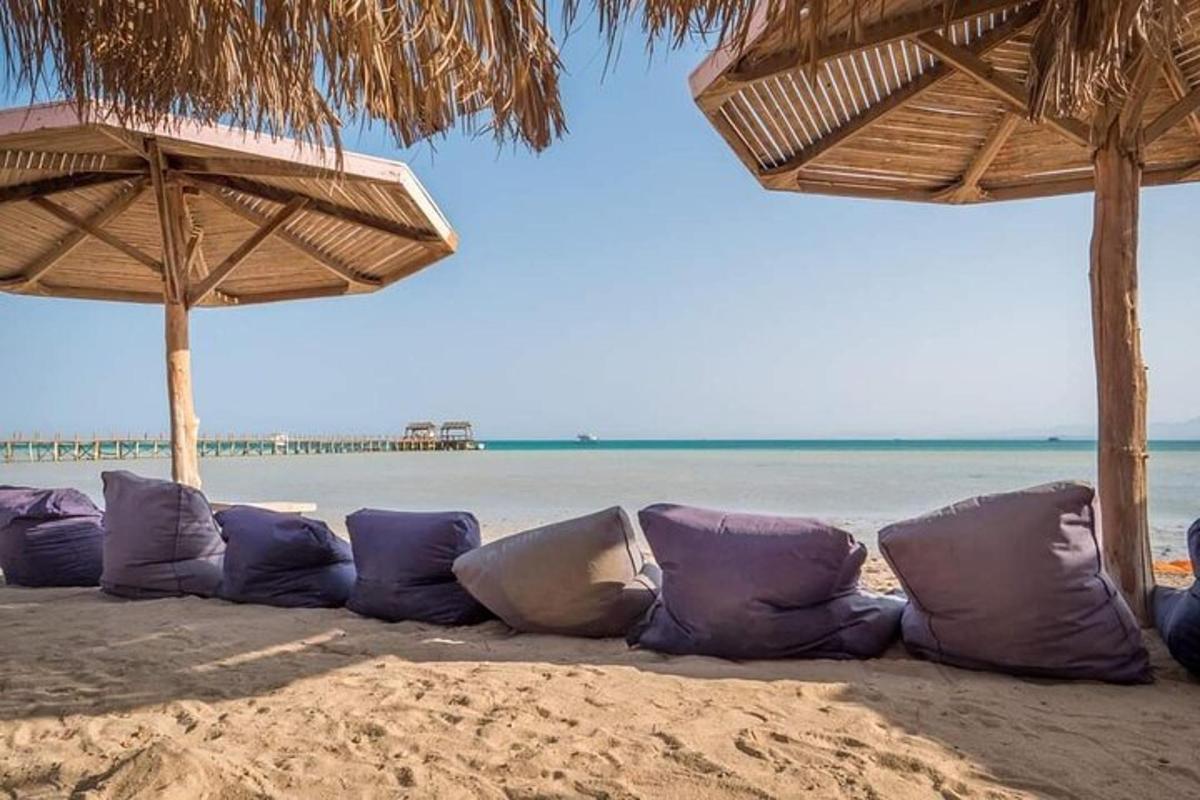 una fila di cuscini su una spiaggia con ombrelloni