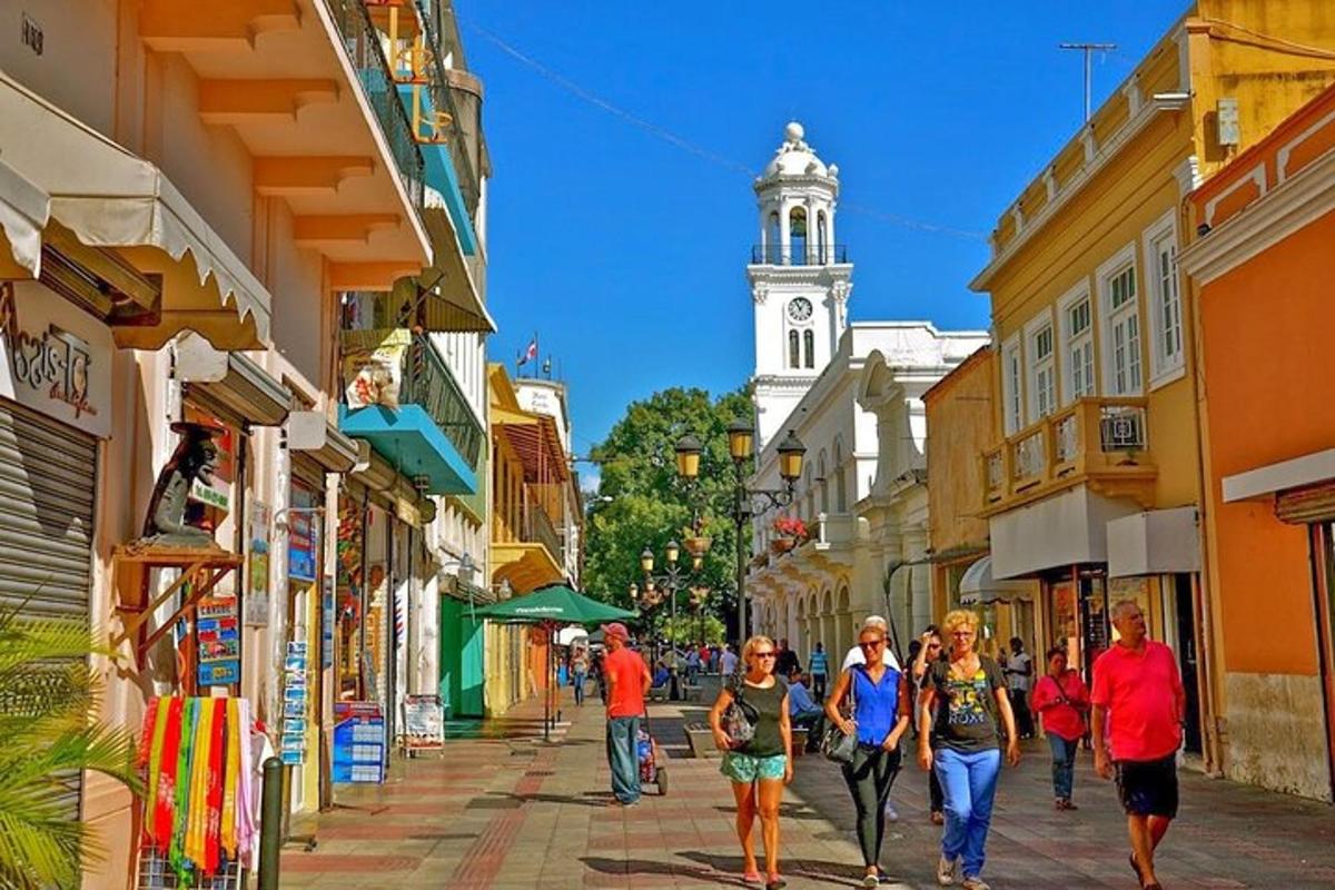 a group of people walking down a street with a clock tower