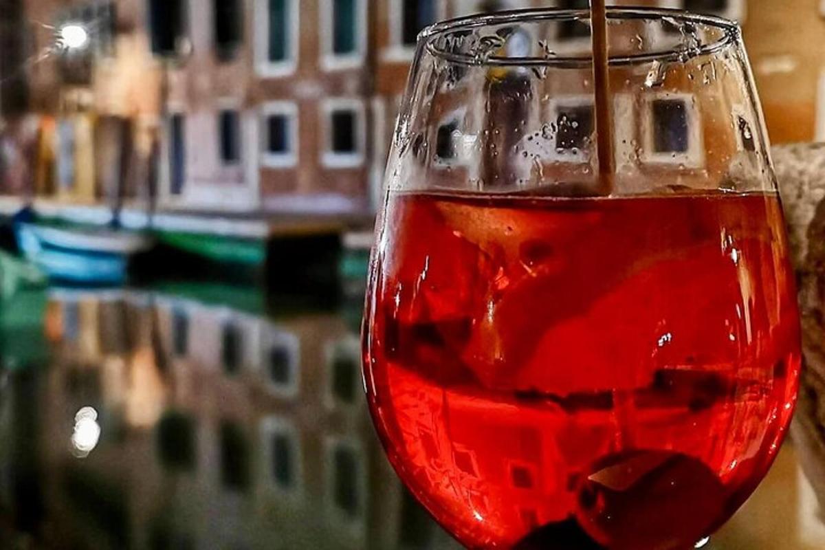 Una copa de vino tinto con un edificio al fondo
