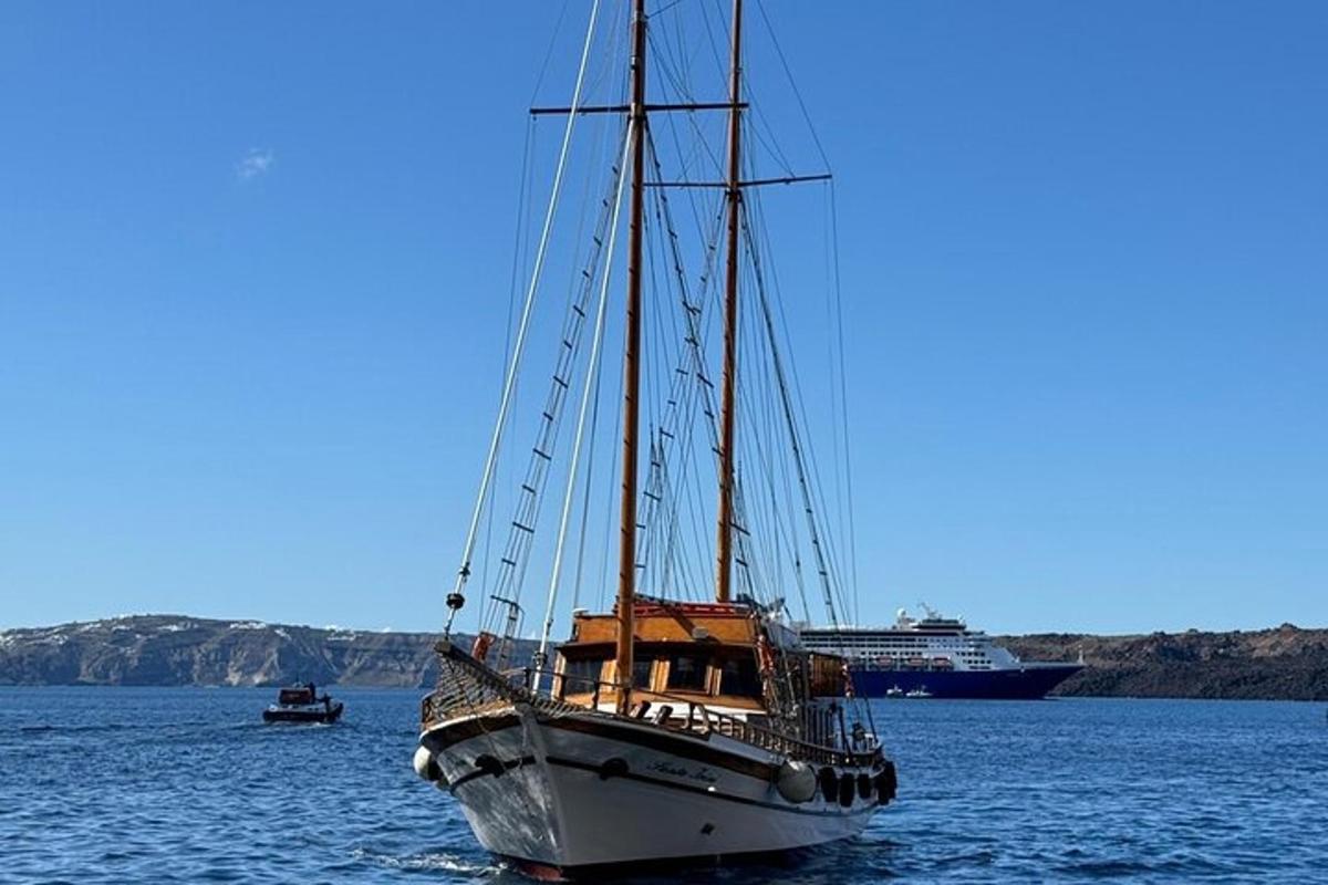 um barco na água com um navio de cruzeiro ao fundo