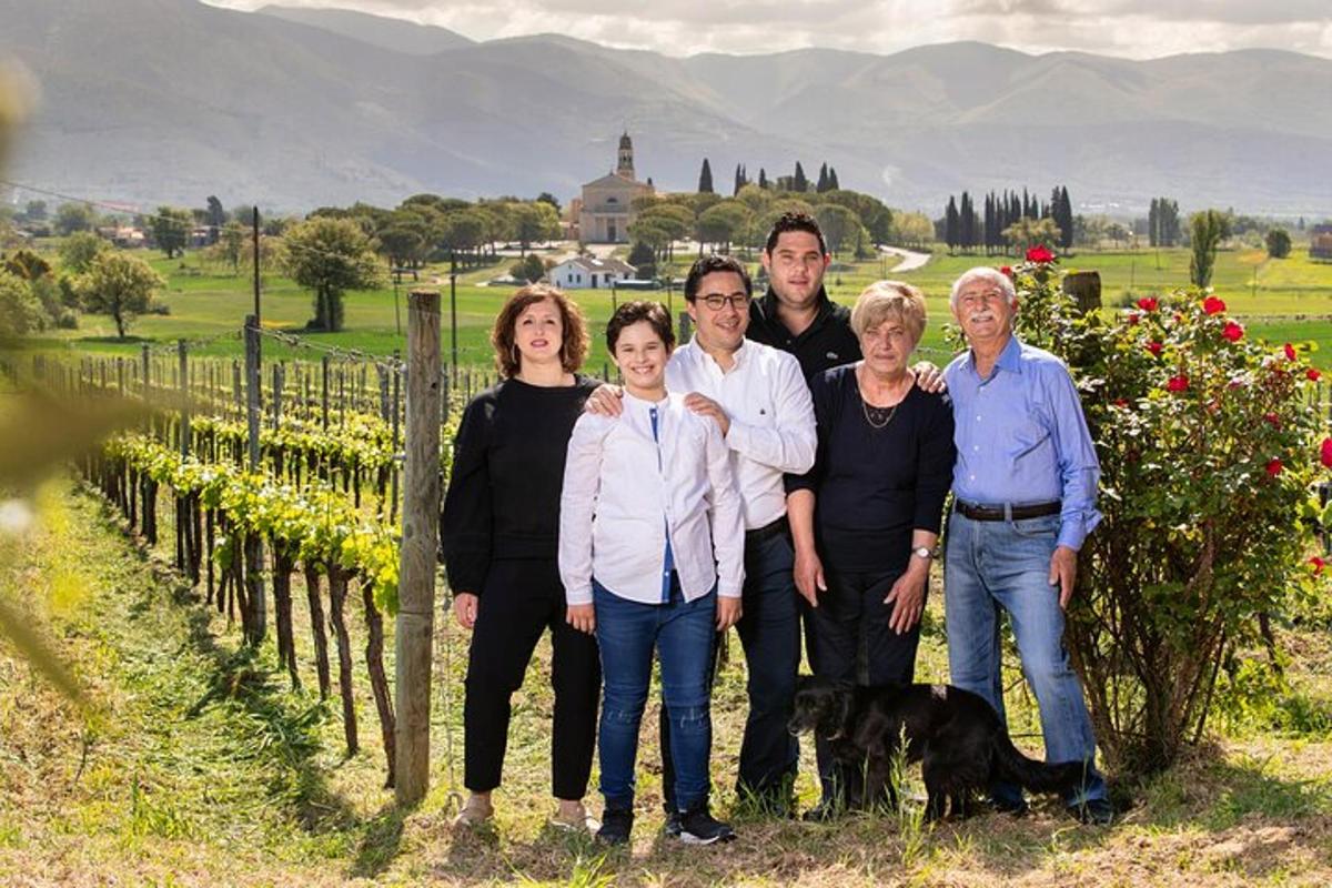 a family poses for a picture in front of a vineyard