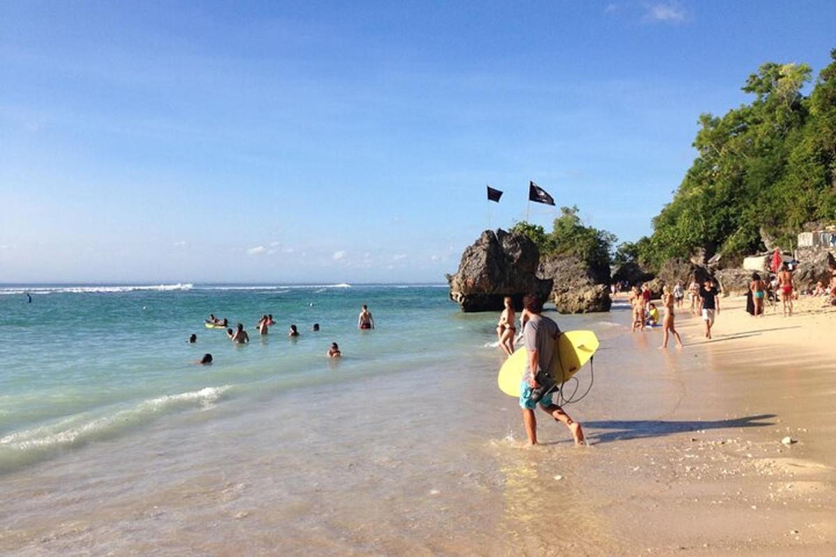 um homem caminhando na praia com uma prancha de surfe