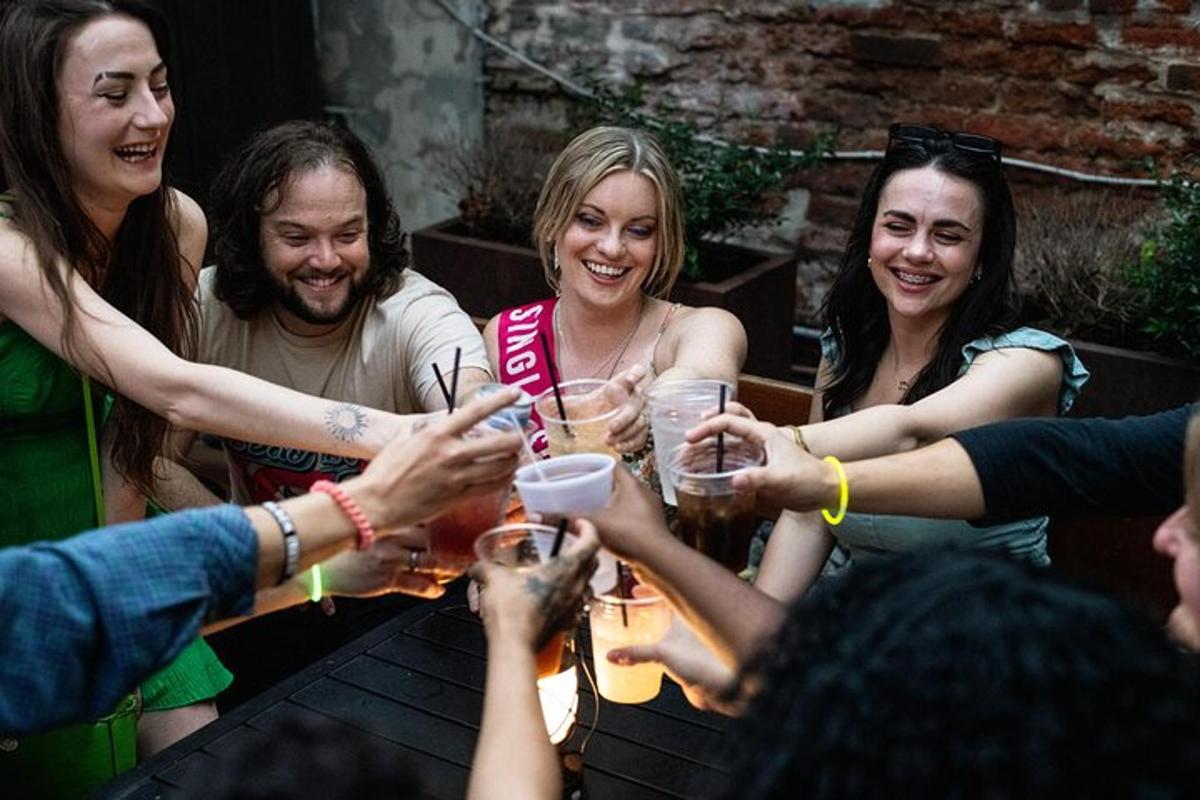 eine Gruppe von Menschen sitzt um einen Tisch und trinkt Bier