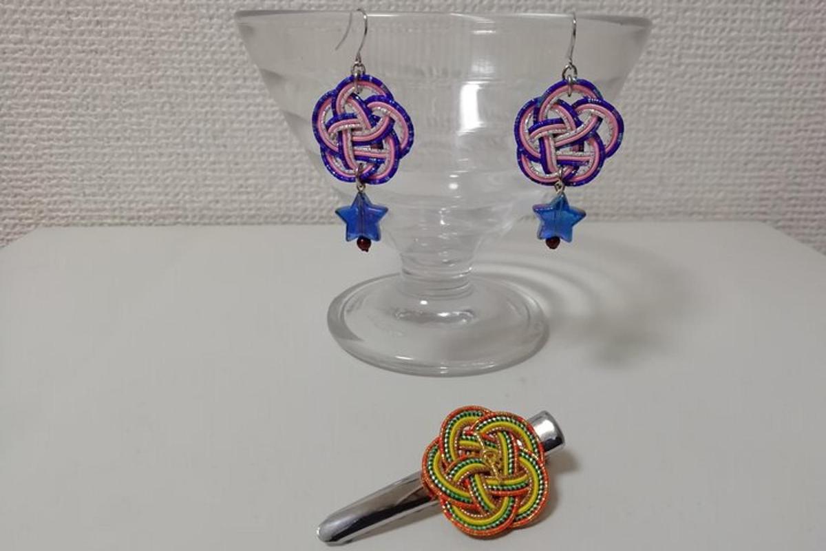a glass vase with a skein of yarn next to a pair of ear
