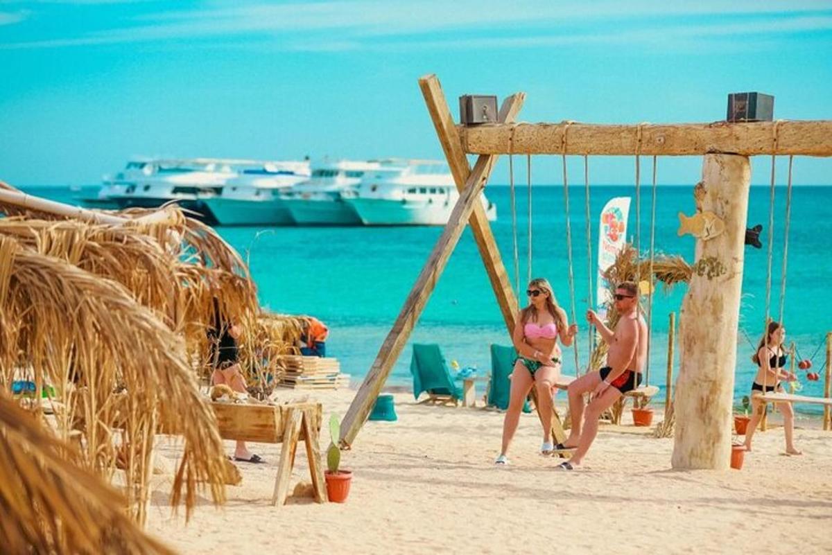 Δύο άτομα κάθονται σε μια κούνια στην παραλία