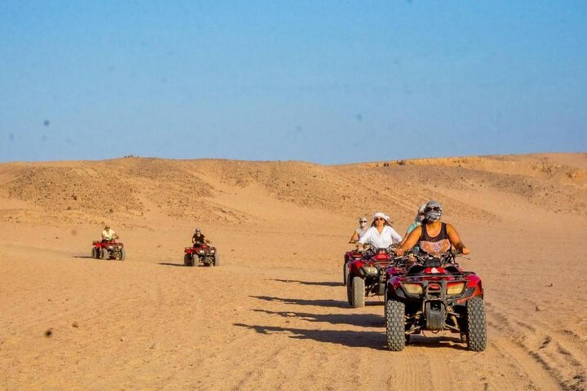 un gruppo di persone che guidano quad nel deserto