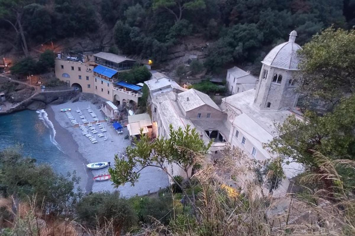 a building on a hill next to a body of water