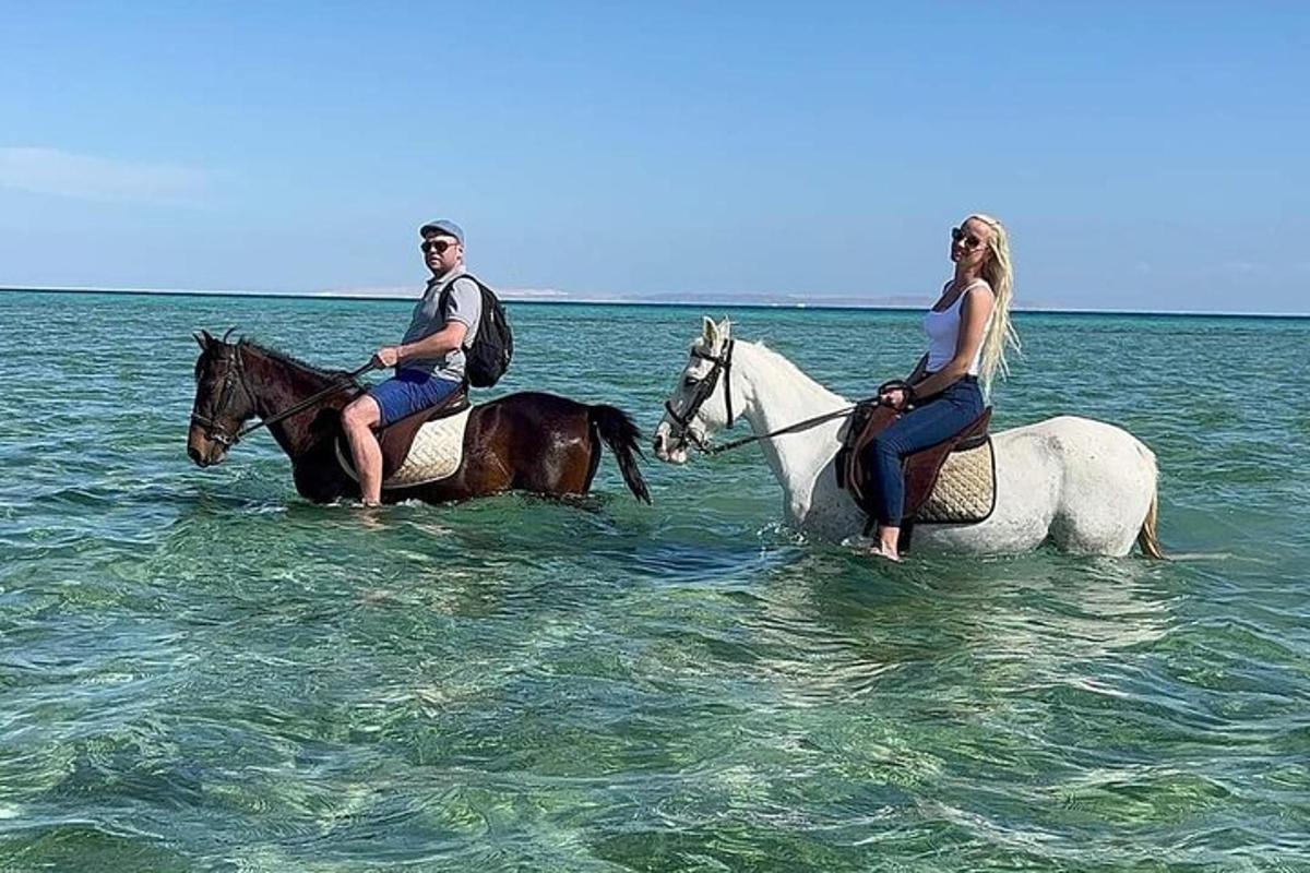 un uomo e una donna a cavallo nell'oceano