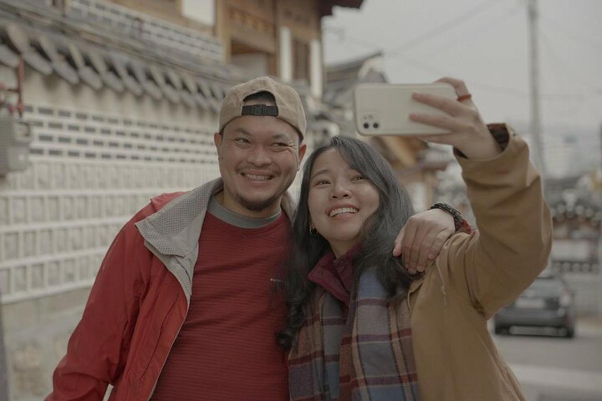 a man and a woman taking a picture with a cell phone