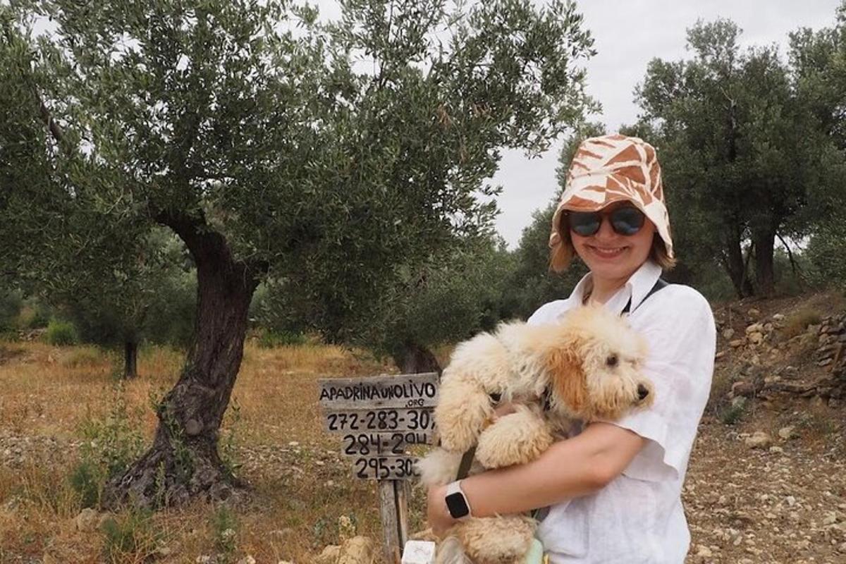 a woman holding two dogs in front of a sign