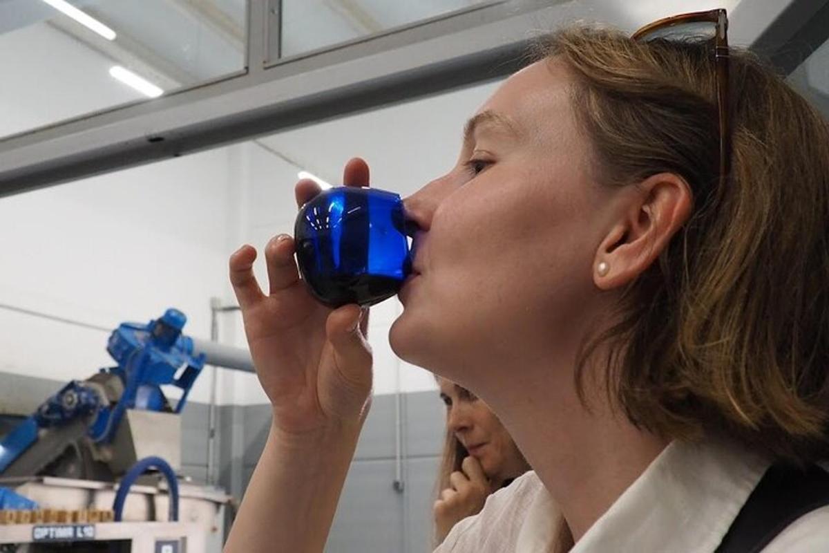 a woman drinking from a blue object in a laboratory
