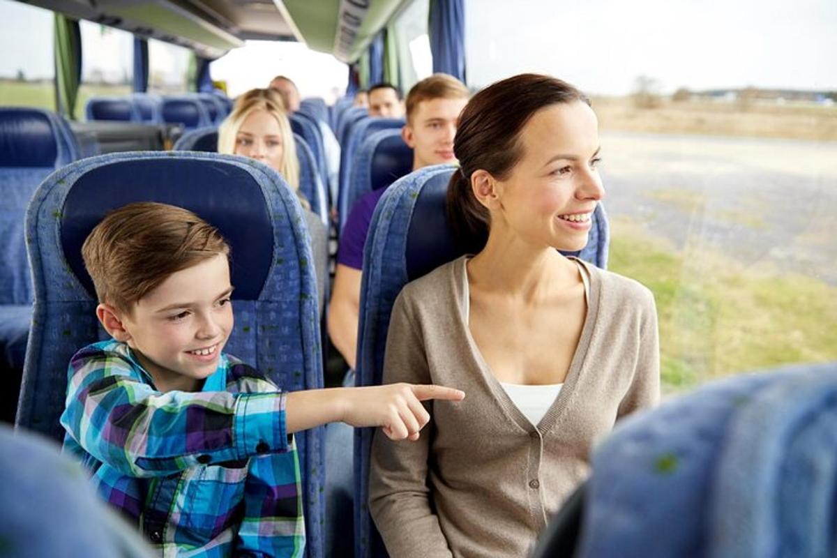 un băiat tânăr arătând spre o femeie într-un autobuz