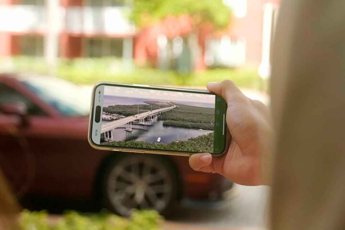 o persoană care fotografiază un pod cu telefonul mobil