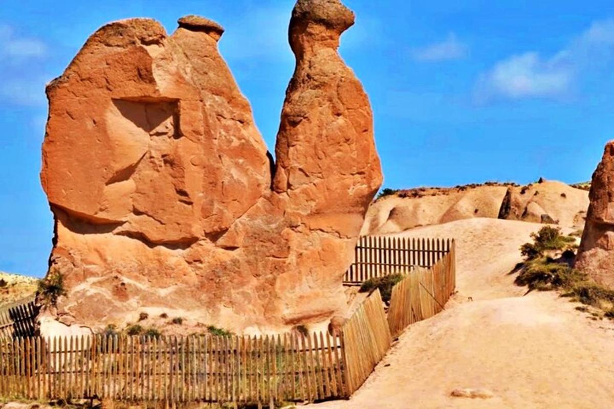 a rock formation behind a fence in the desert