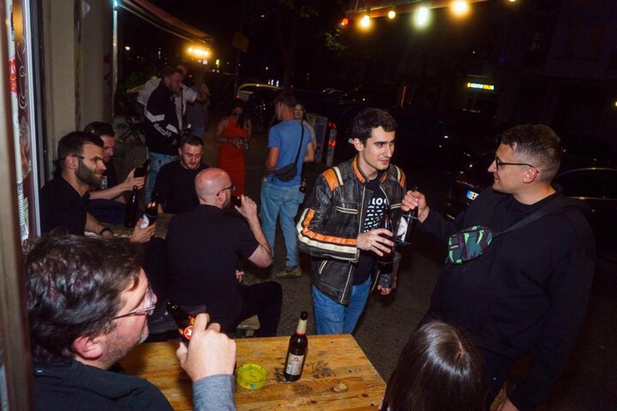 un grup de persones al voltant d'una taula amb ampolles de cervesa