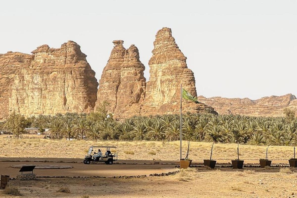 a vehicle driving in front of some large rocks