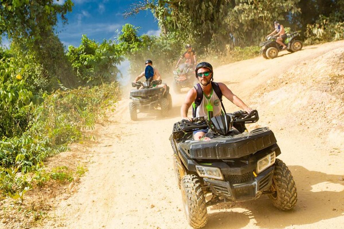 un uomo che guida un quad su una strada sterrata