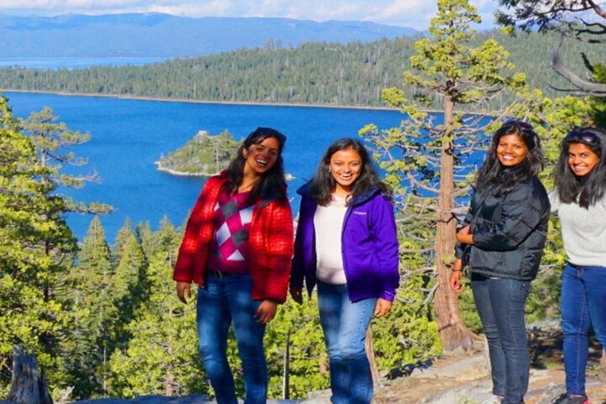 um grupo de mulheres em pé em frente a um lago
