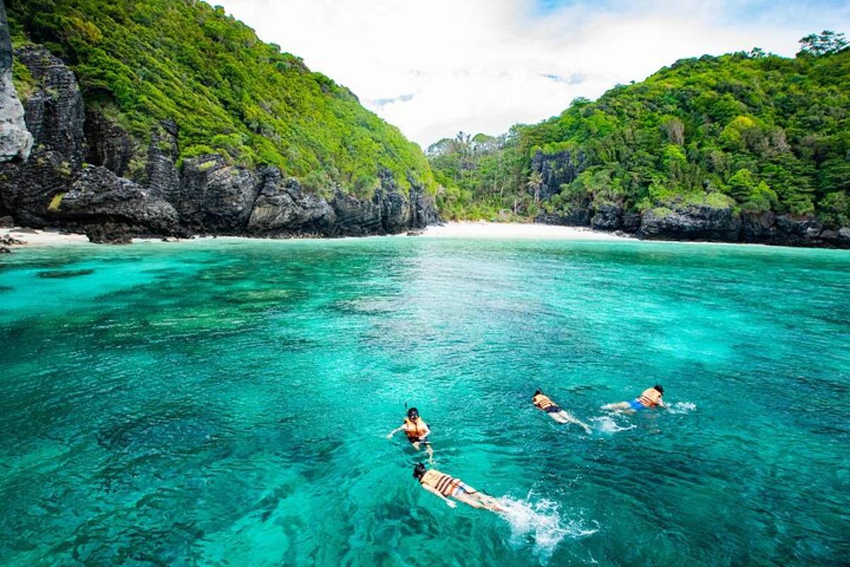 Tres personas nadando en el agua cerca de una playa