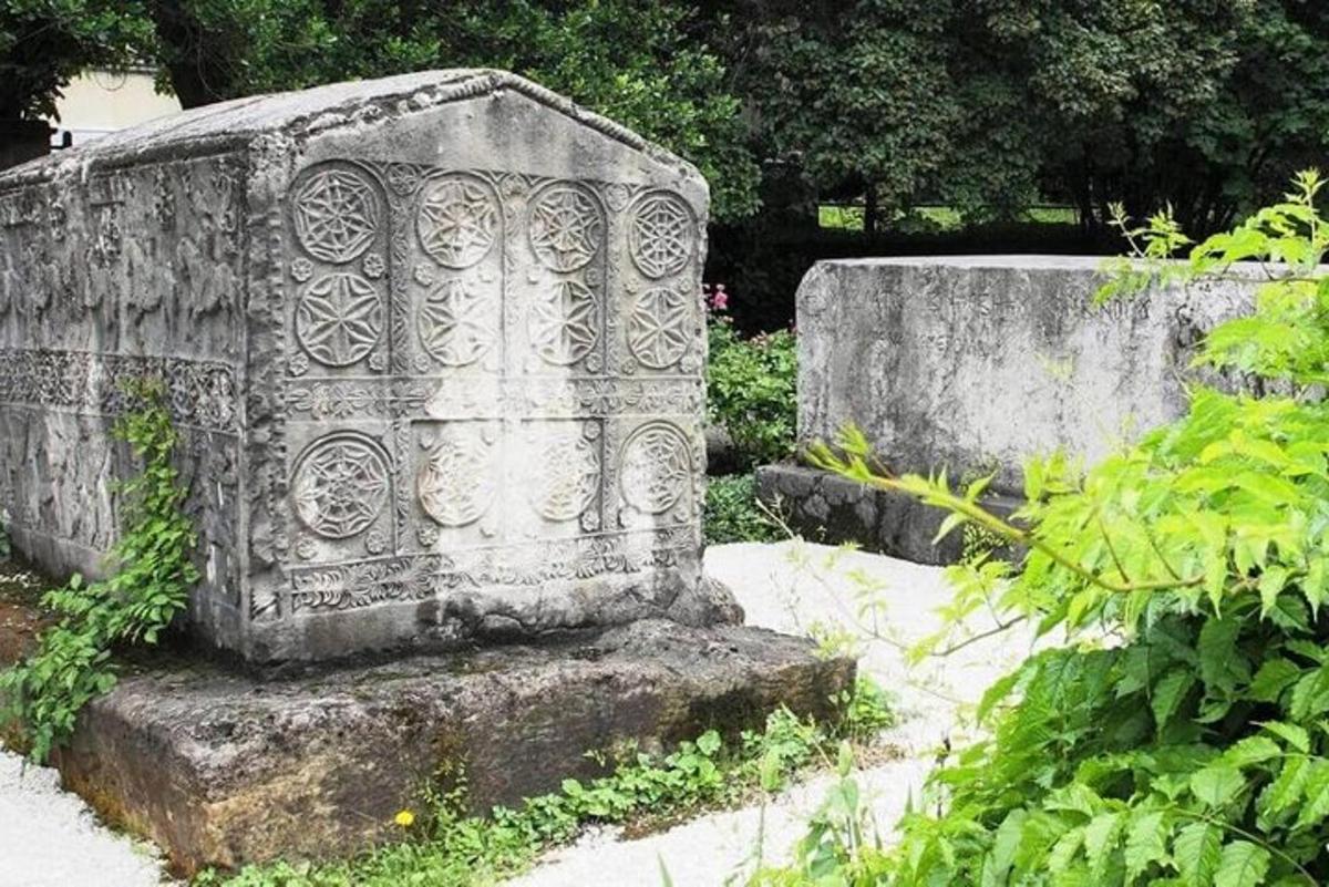 kamenný graveolit v zahradě s rostlinami