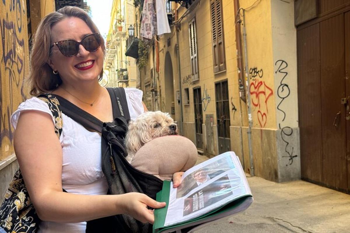 eine Frau mit einem Hund in einer Tasche, die eine Zeitschrift hält