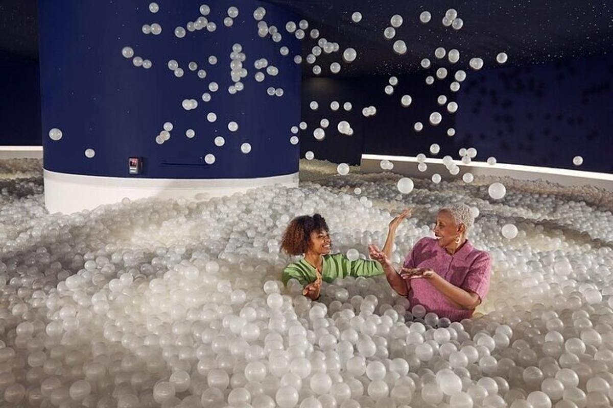 two people sitting in a pool of balls