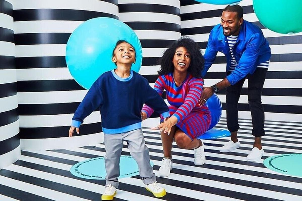 a family posing in front of a room with balloons