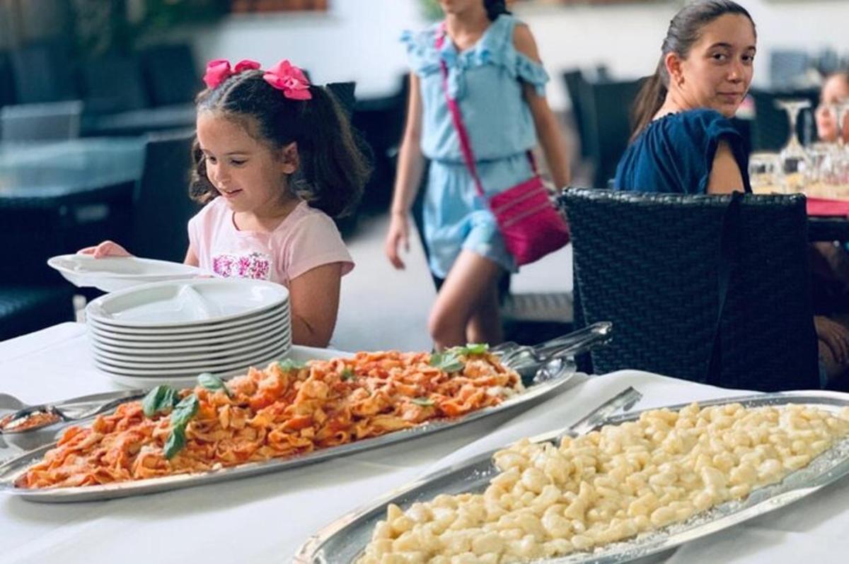 Una niña sentada en una mesa con una bandeja de comida.