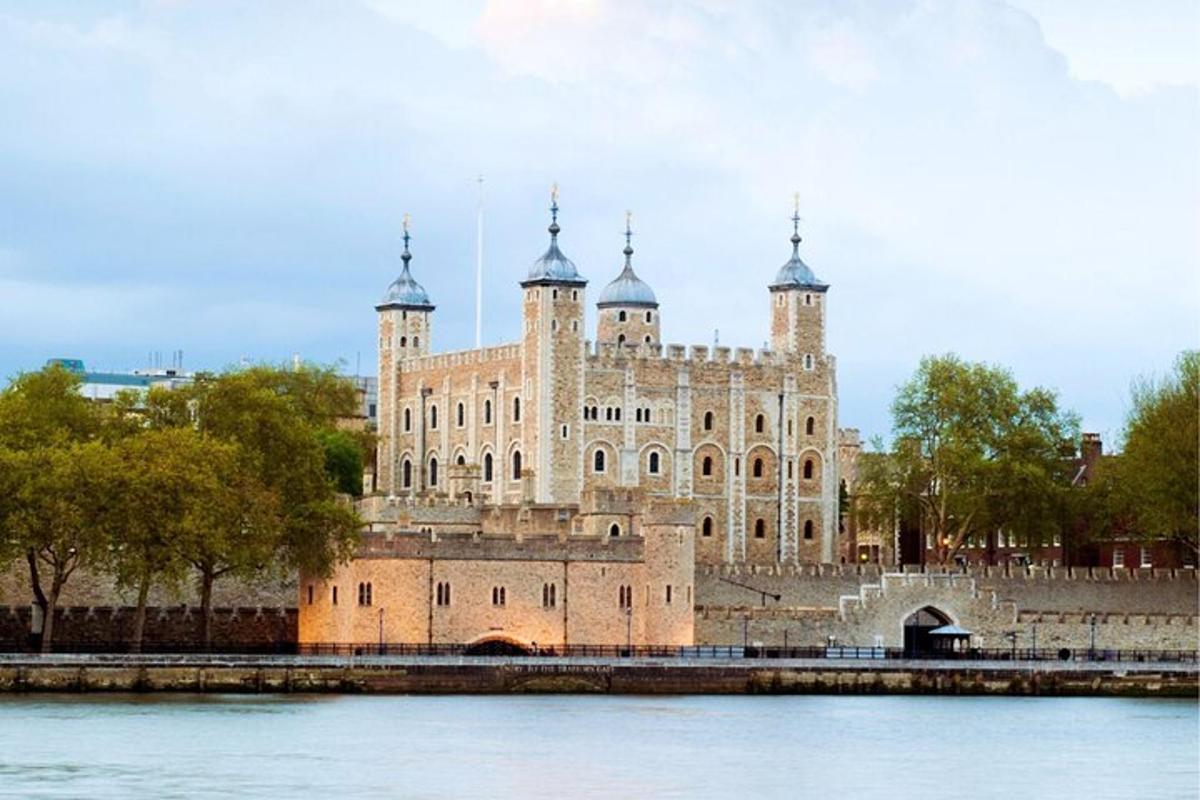 a large building with towers on the side of a river