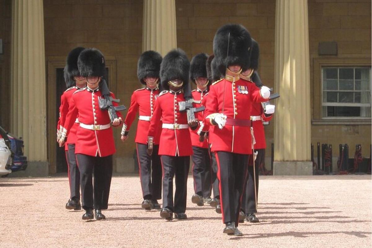 a group of soldiers in red uniforms walking past a building