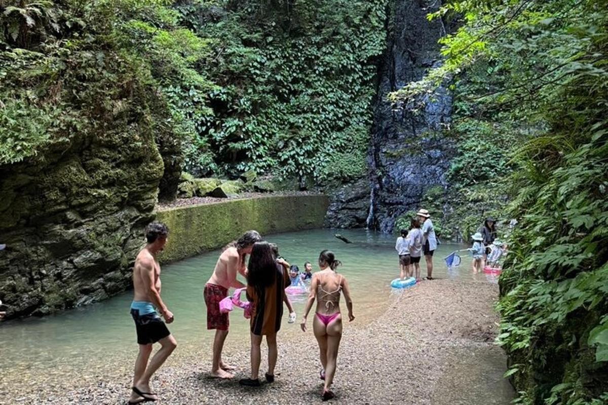 sekumpulan orang berdiri di dalam air di sungai