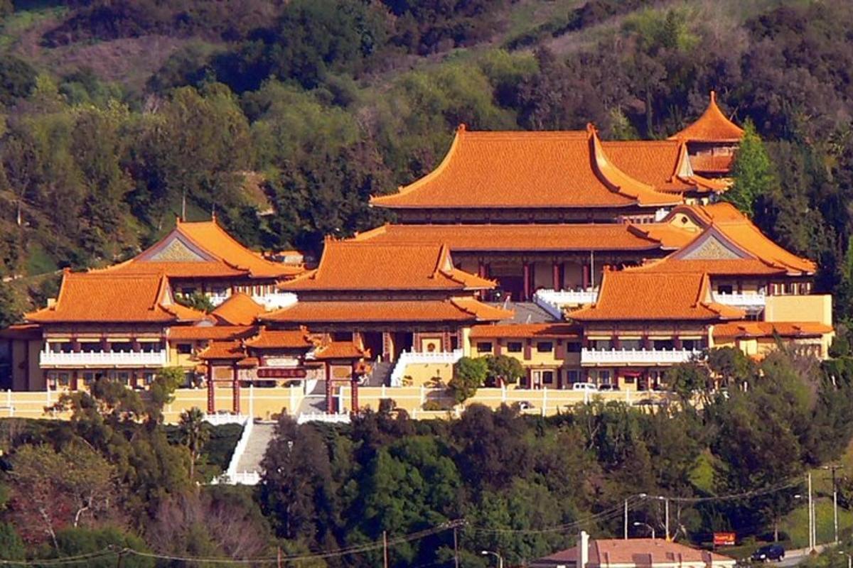a large building with orange roofs on a mountain