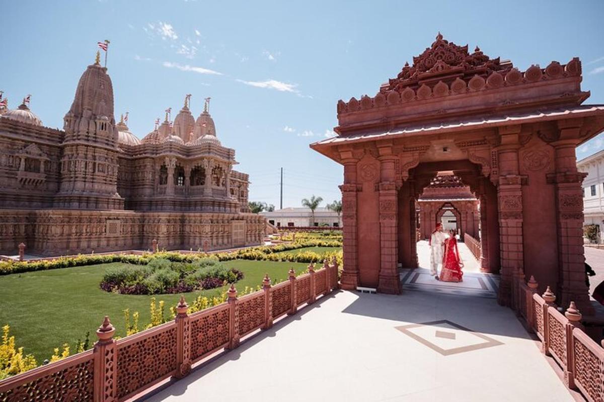 a woman walking through a gate in a garden