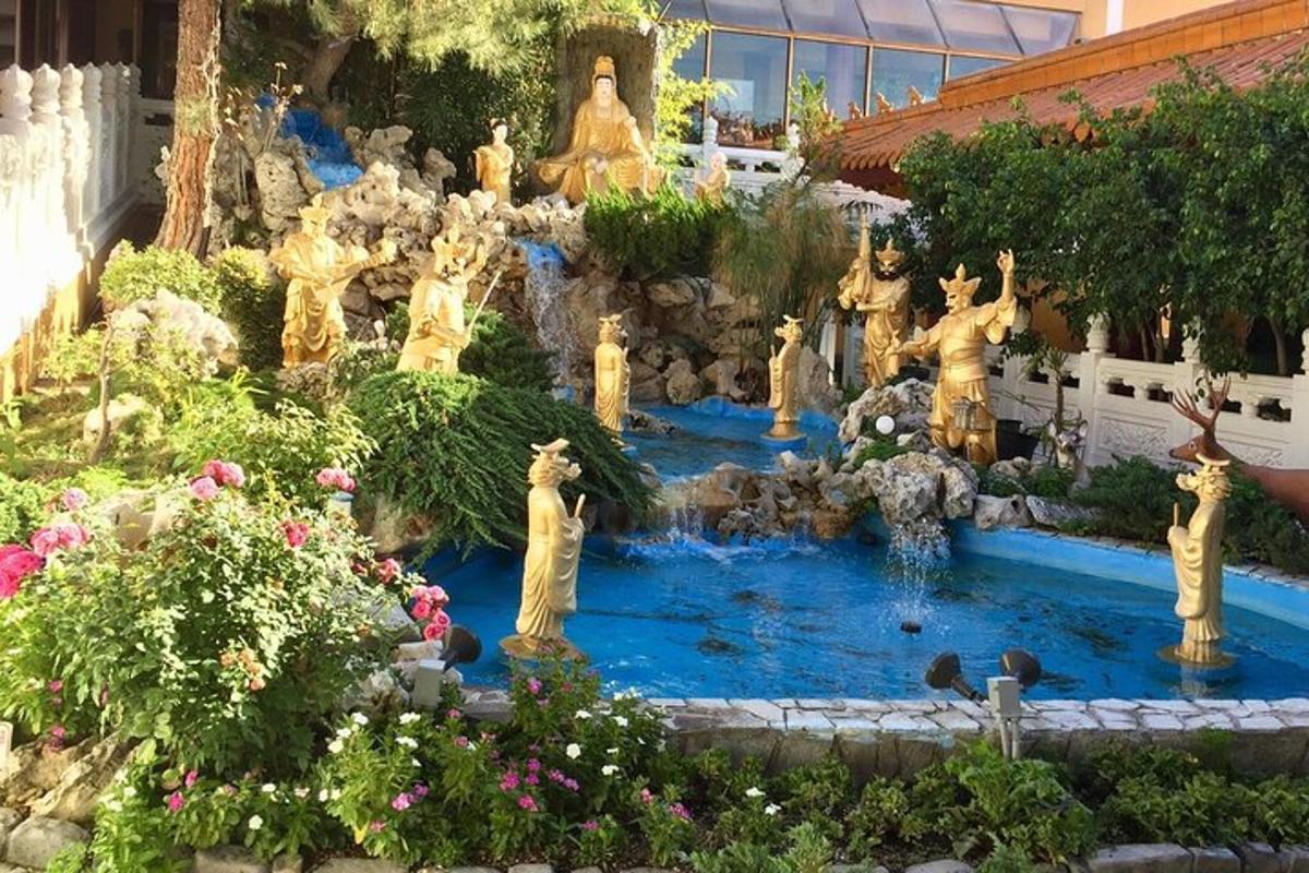 Un jardín con estatuas en medio de una fuente.