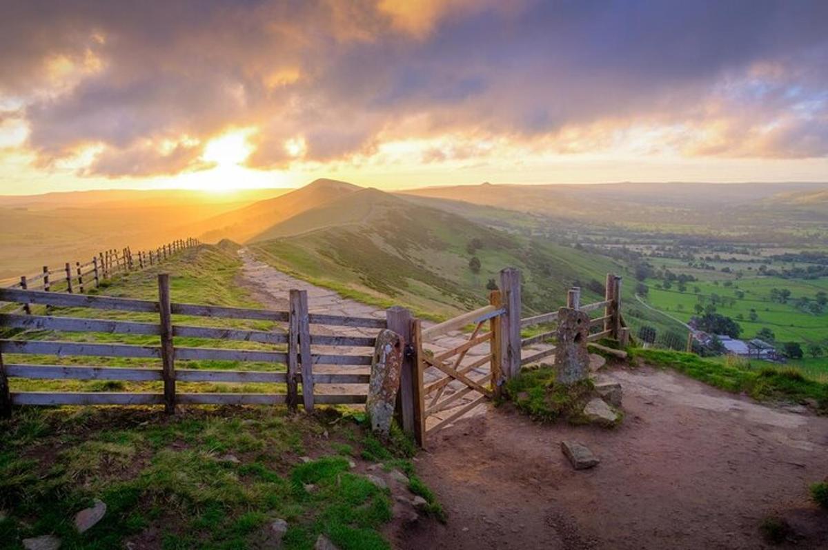 a fence on top of a hill with a sunset