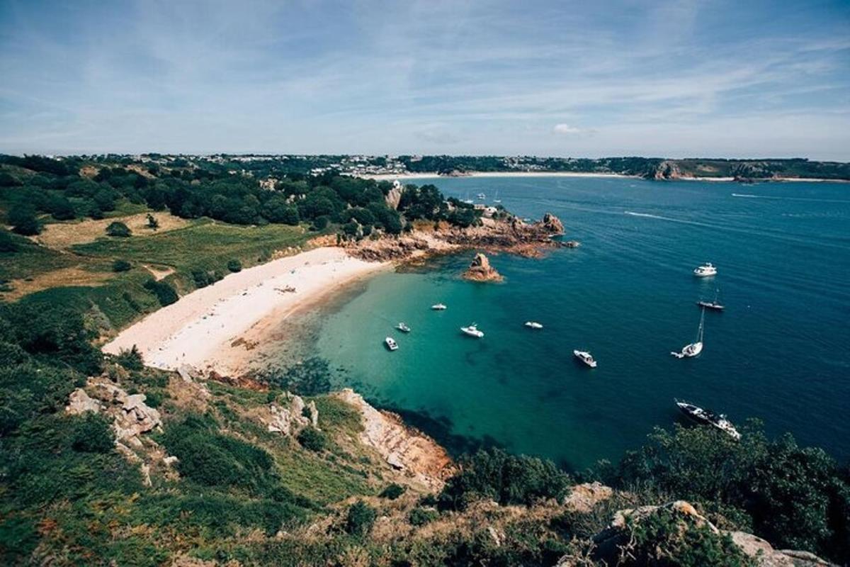 an aerial view of a beach with boats in the water
