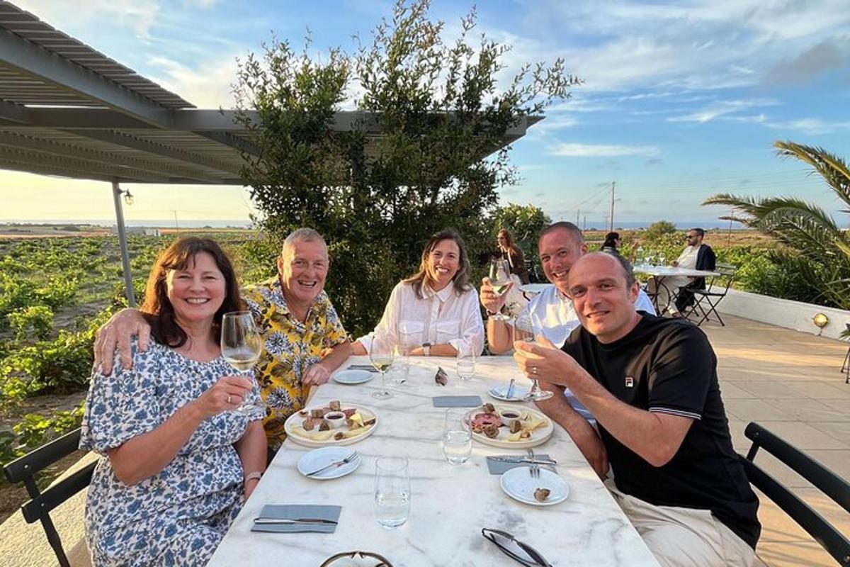 un gruppo di persone sedute a un tavolo con bicchieri di vino