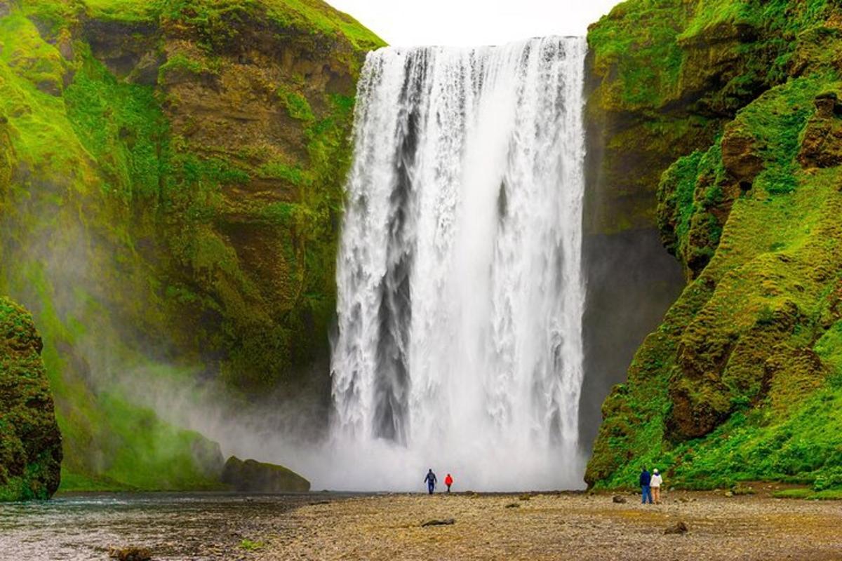 people standing at the base of a waterfall