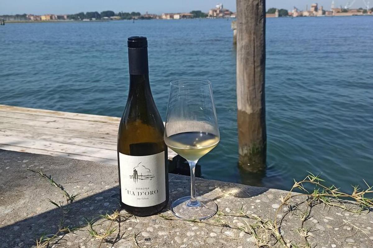una bottiglia di vino bianco accanto a un bicchiere di vino