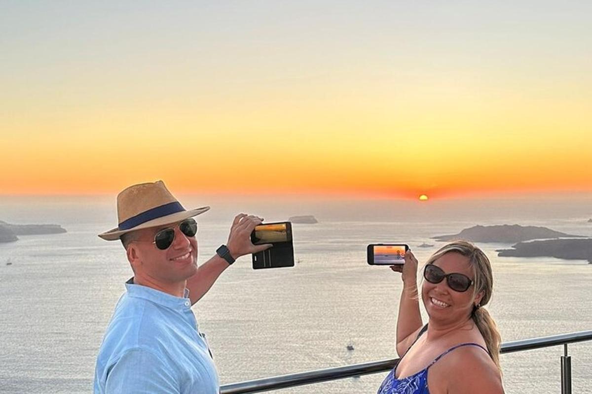 un uomo e una donna che scattano foto del tramonto