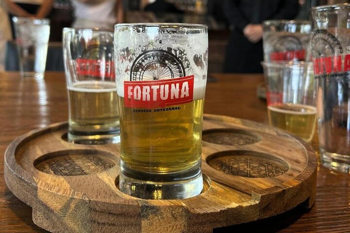 Un vaso de cerveza sobre un posavasos de madera.
