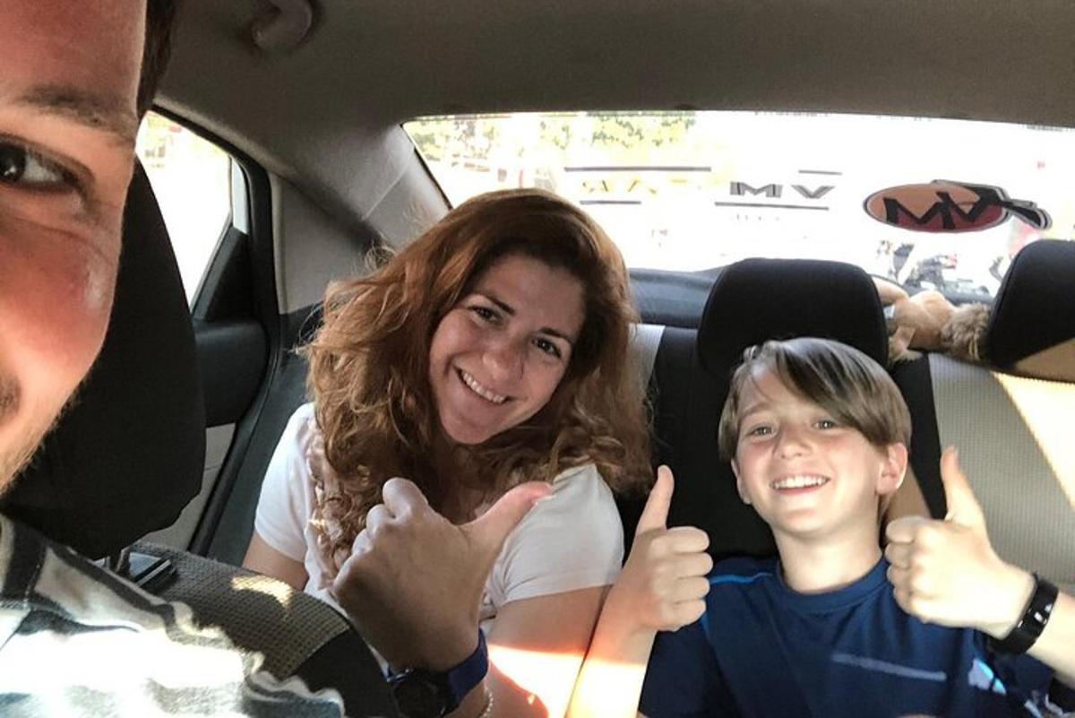 une femme et un garçon assis dans une voiture levant les pouces