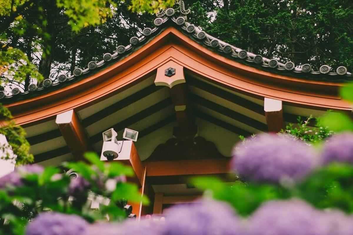 a small building with a roof with purple flowers