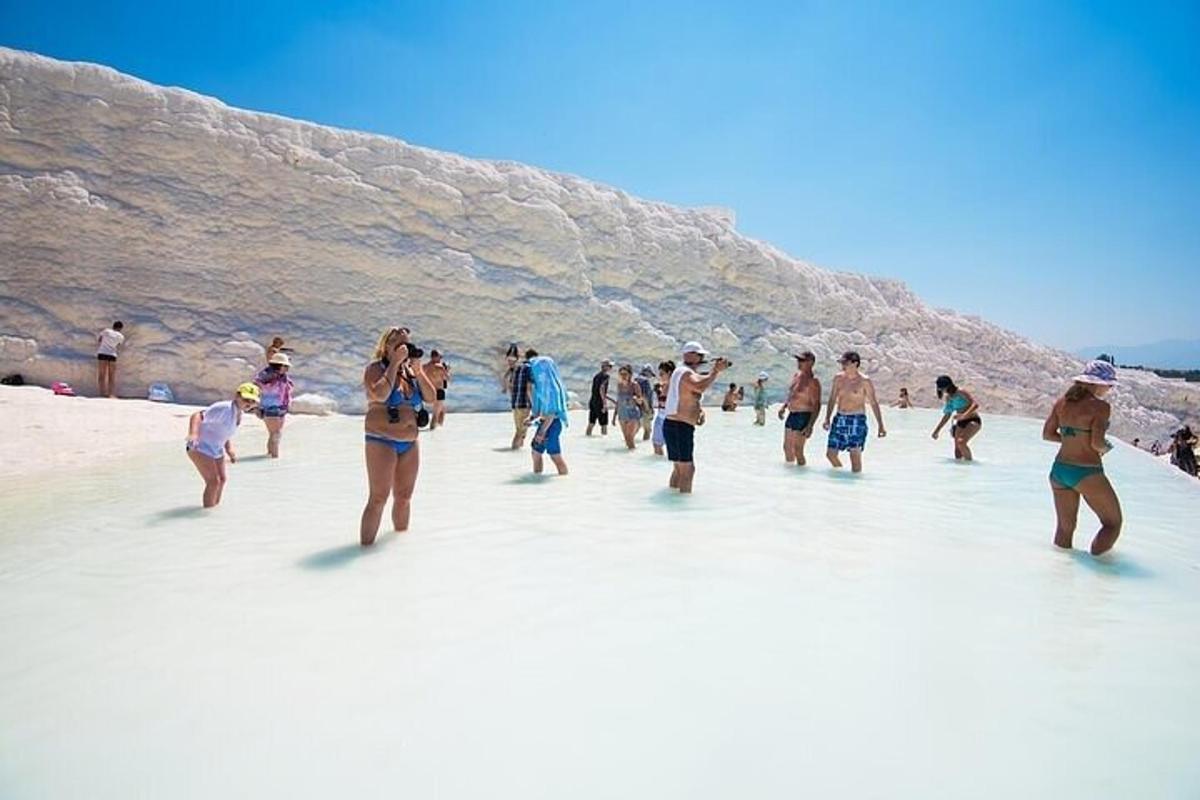 un gruppo di persone che camminano nell'acqua su una spiaggia