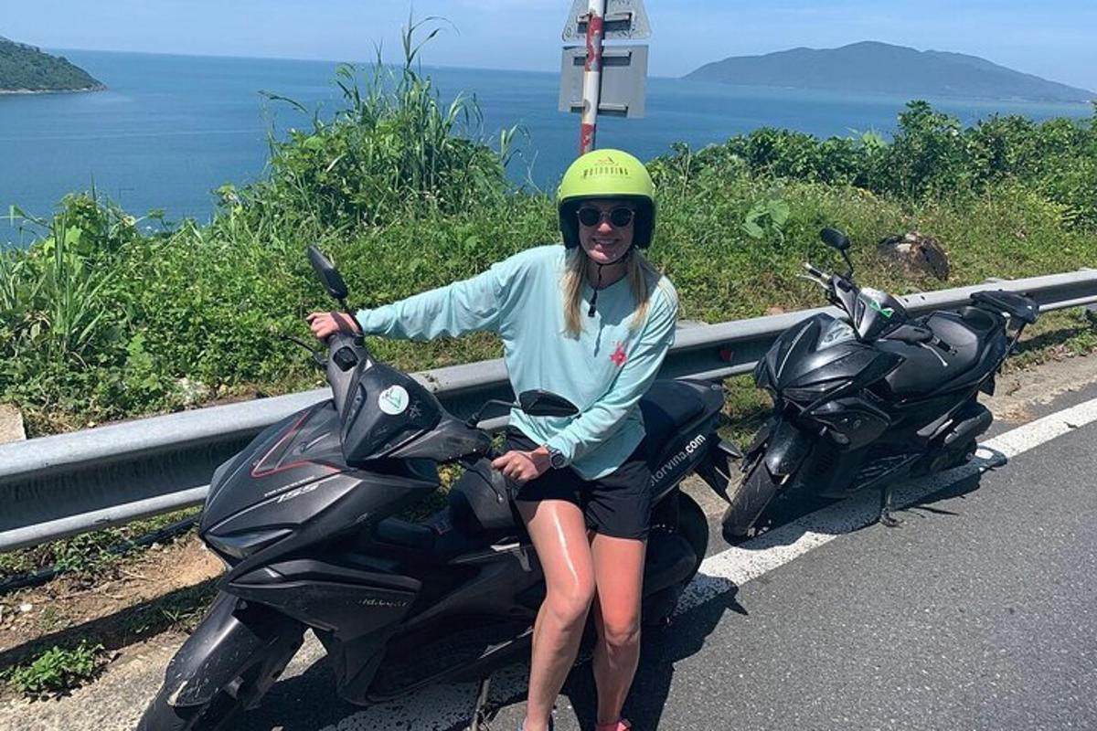 žena sediaca na motorke na kraji cesty