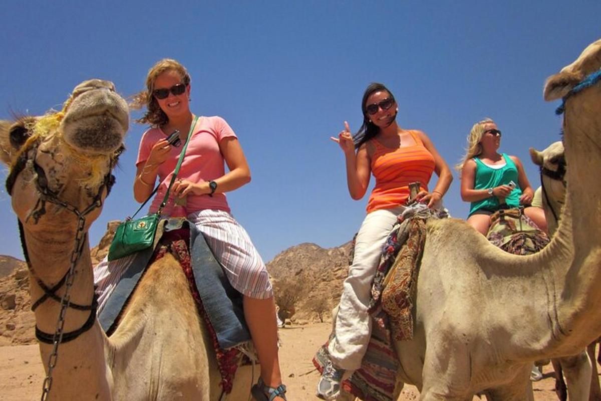 drei Frauen reiten auf Kamelen in der Wüste