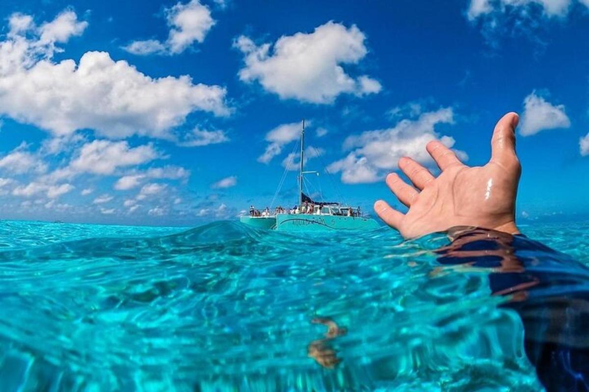 a hand in the water with a boat in the background