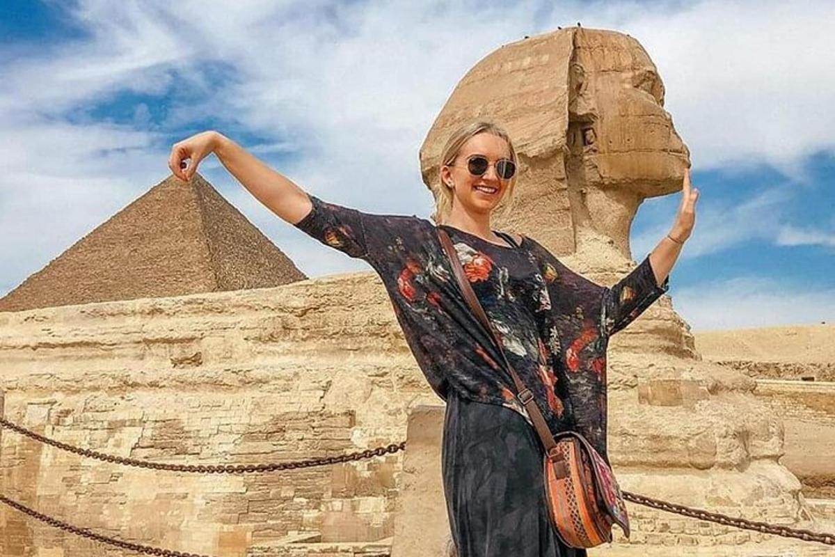 nainen seisoo pyramidin edessä