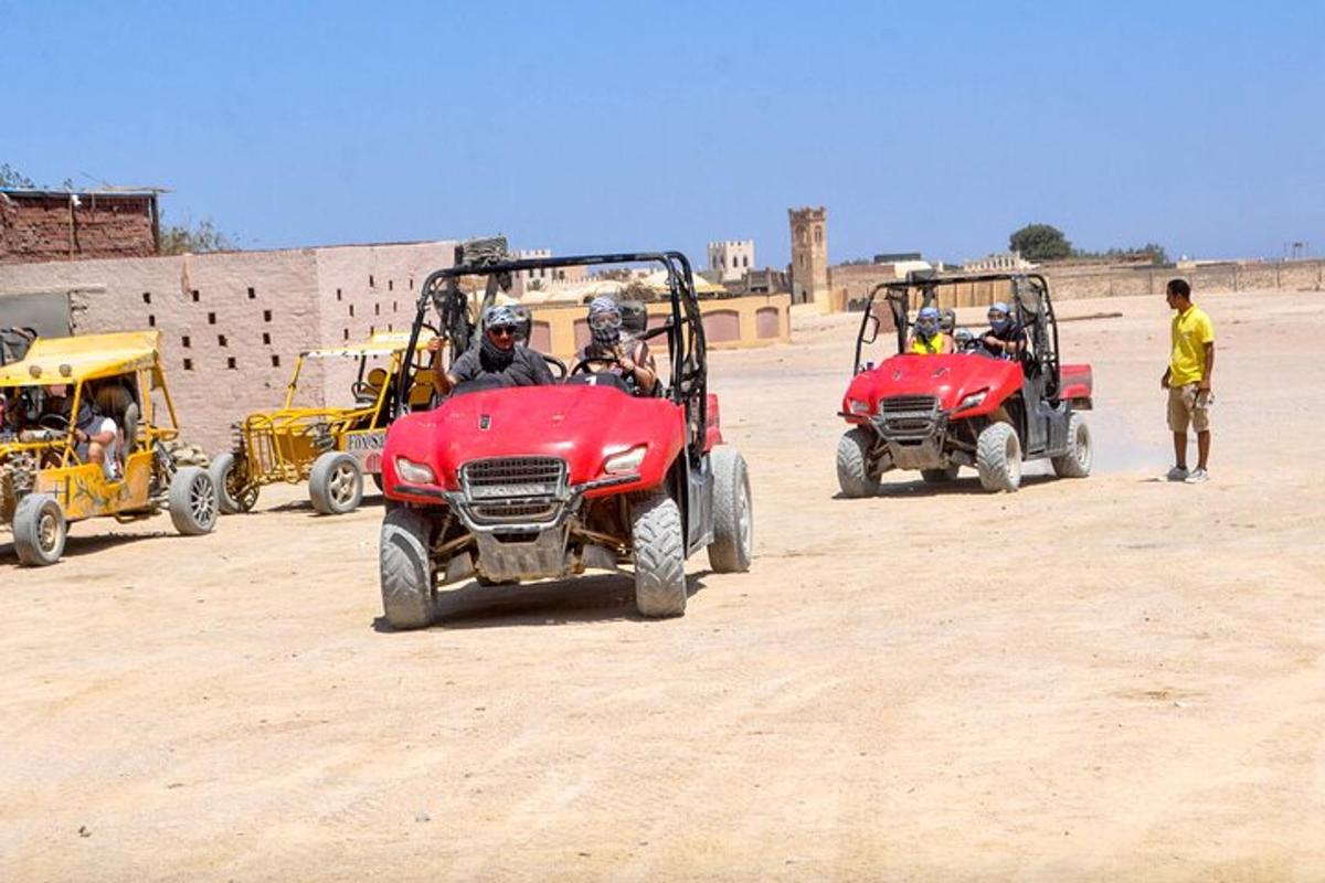 un grup de persones conduint quads al desert